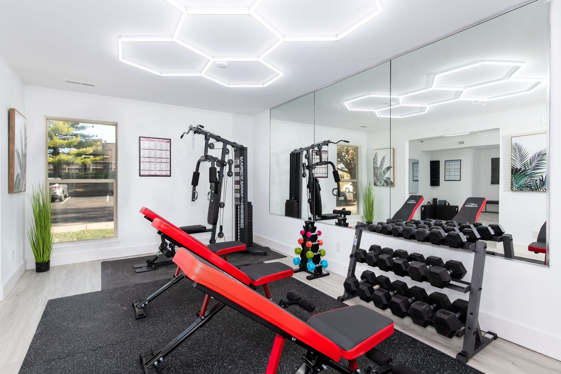 A home gym with a lot of equipment and a large mirror.