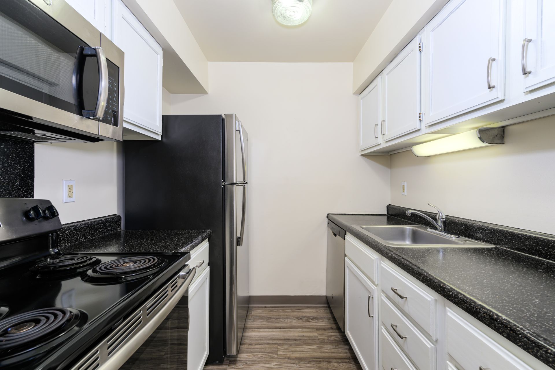 A kitchen with black appliances and white cabinets