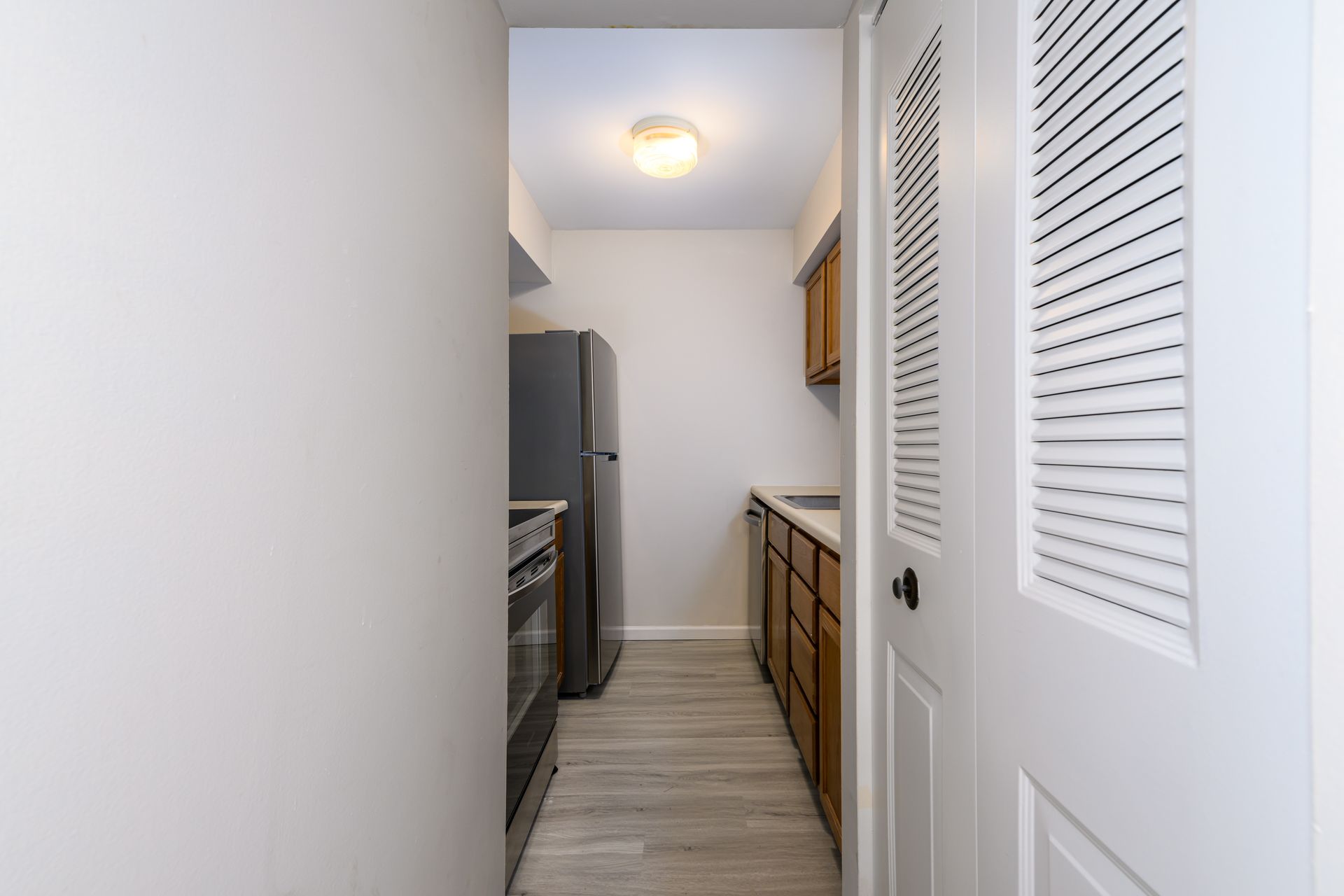 A kitchen with a refrigerator , stove , sink and cabinets.
