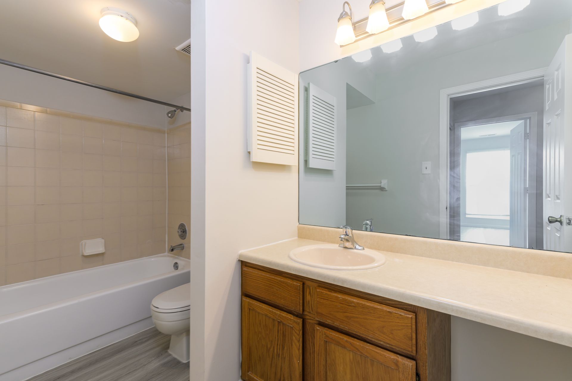 A bathroom with a sink , toilet , tub and mirror.