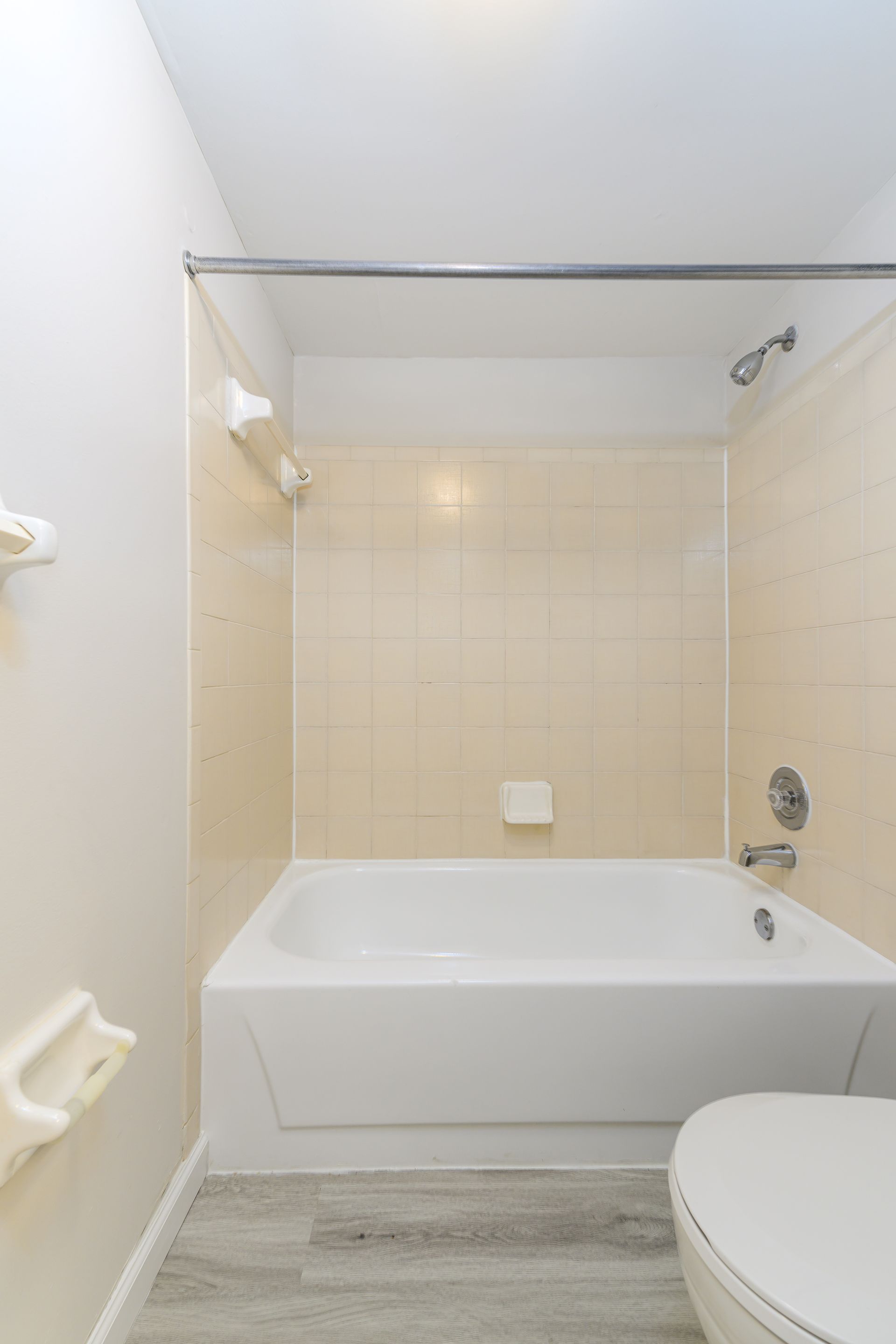 A bathroom with a tub , toilet and shower.