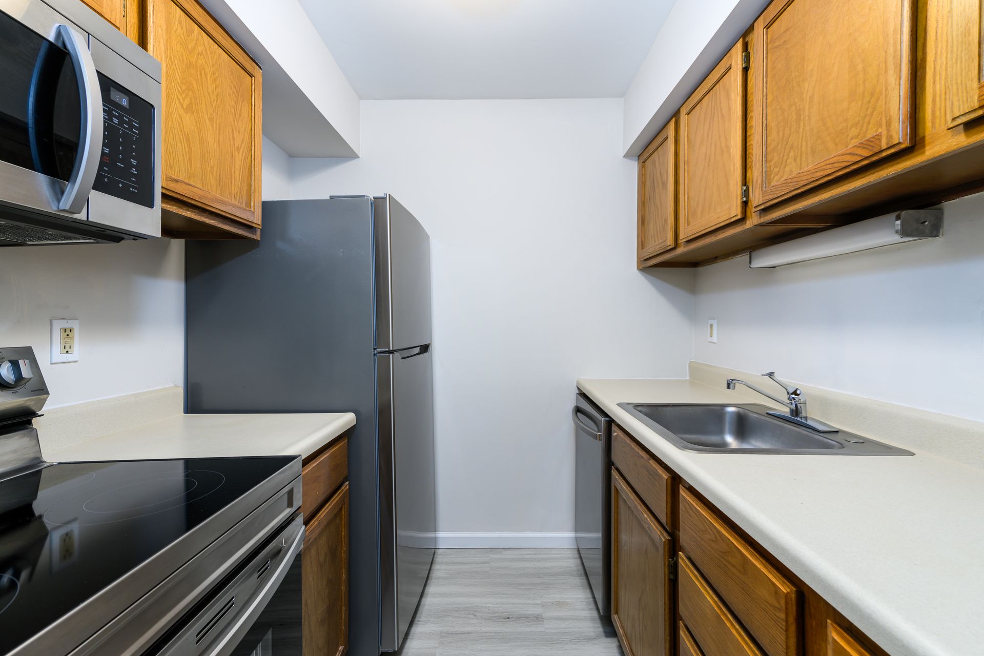 A kitchen with stainless steel appliances and wooden cabinets