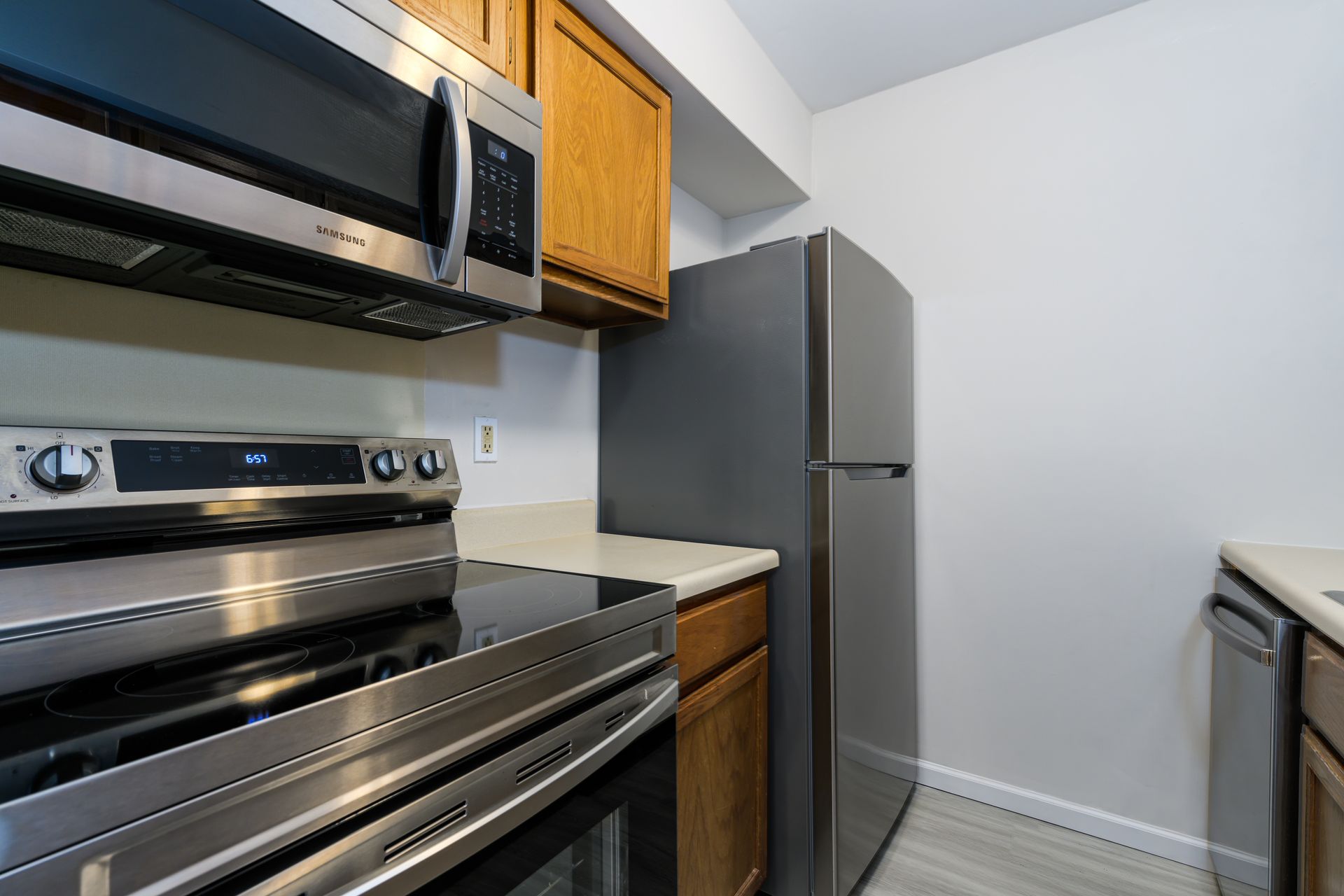 A kitchen with a stove , microwave , refrigerator and dishwasher.