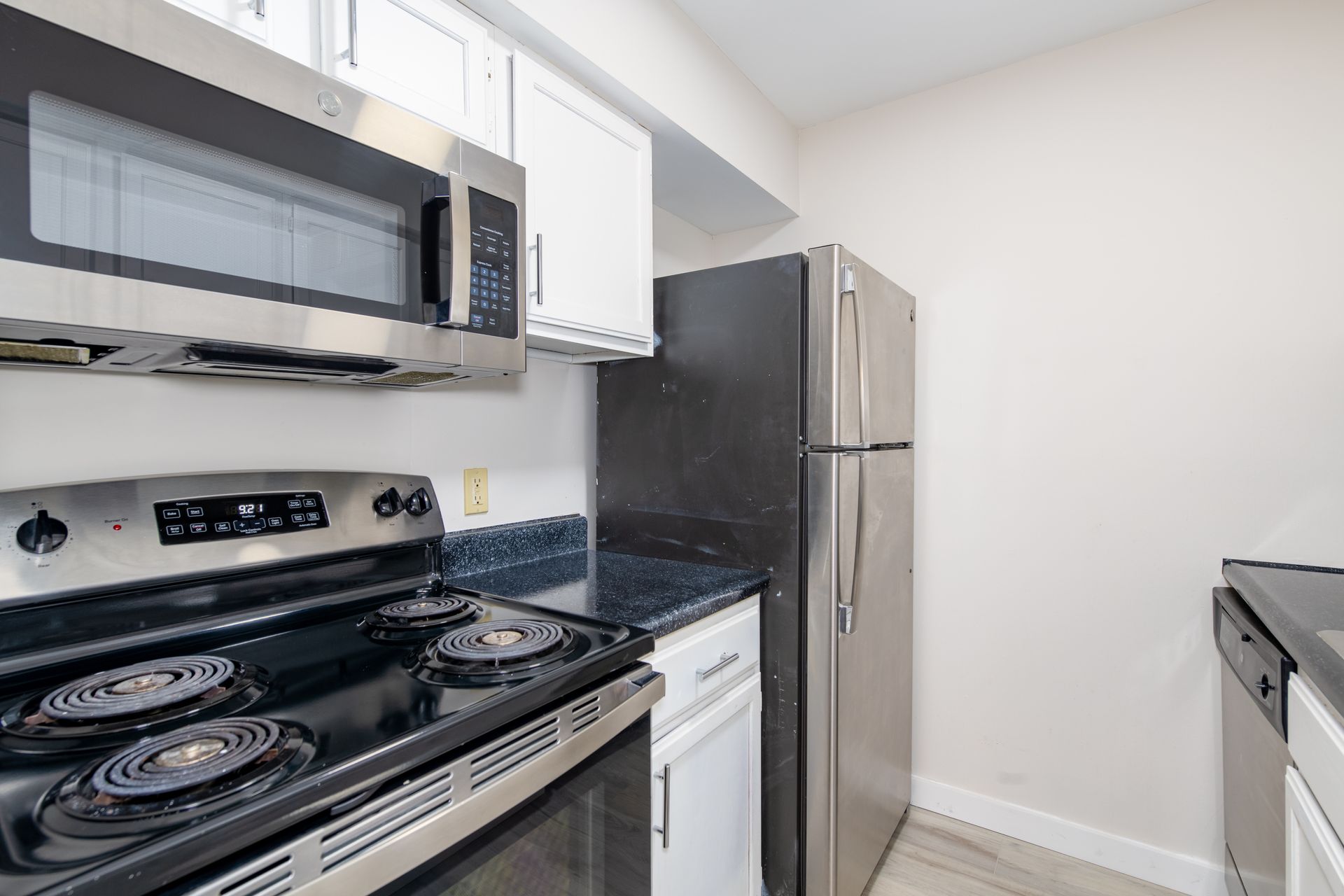 A kitchen with a stove , refrigerator , microwave and dishwasher.