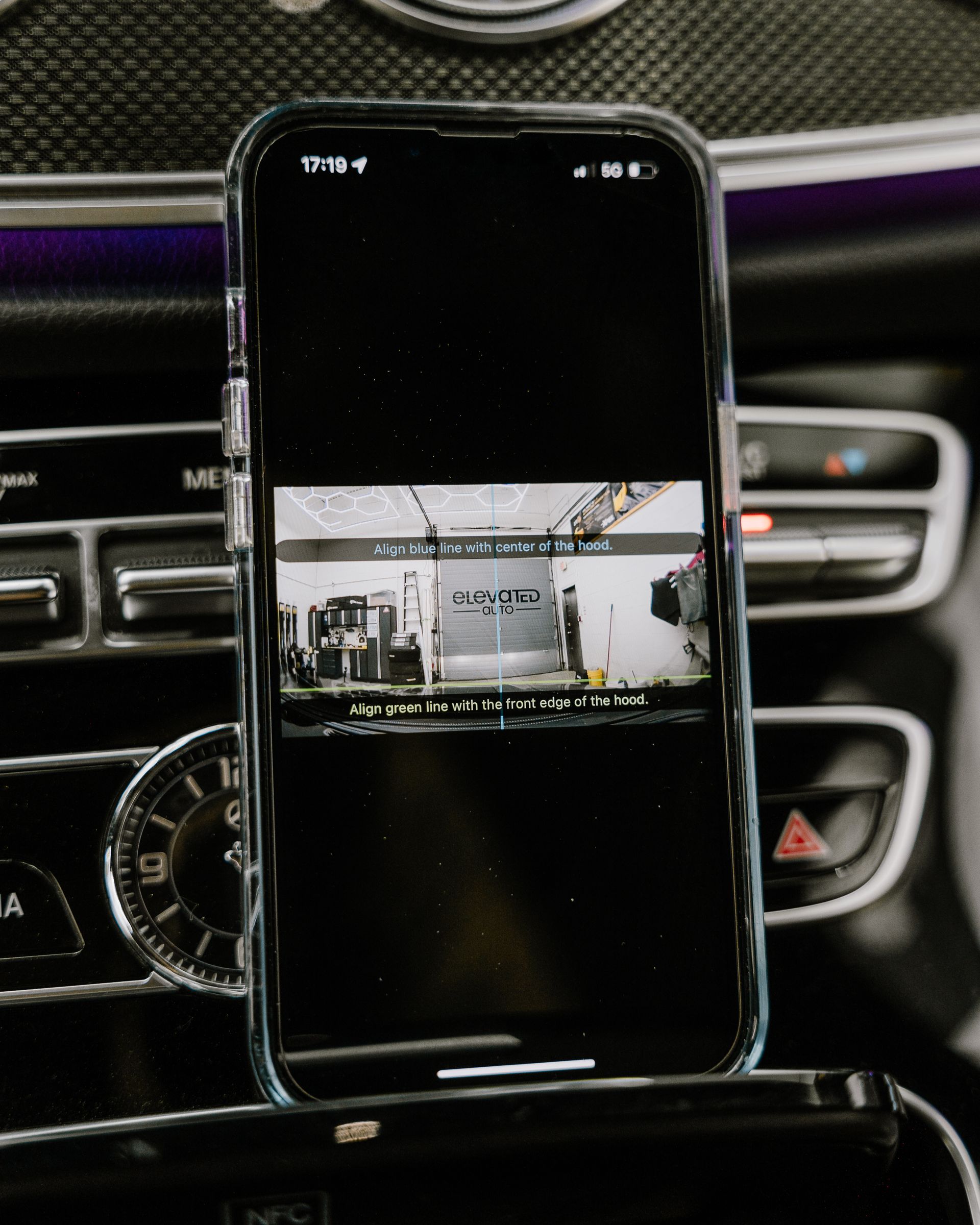 A cell phone is sitting on top of a car dashboard.