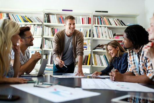 A group of people are sitting around a table playing a game.