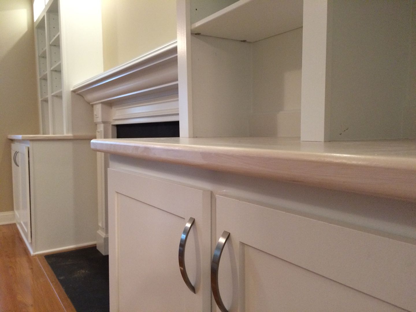 White cabinets with light countertops and a fireplace in a room.