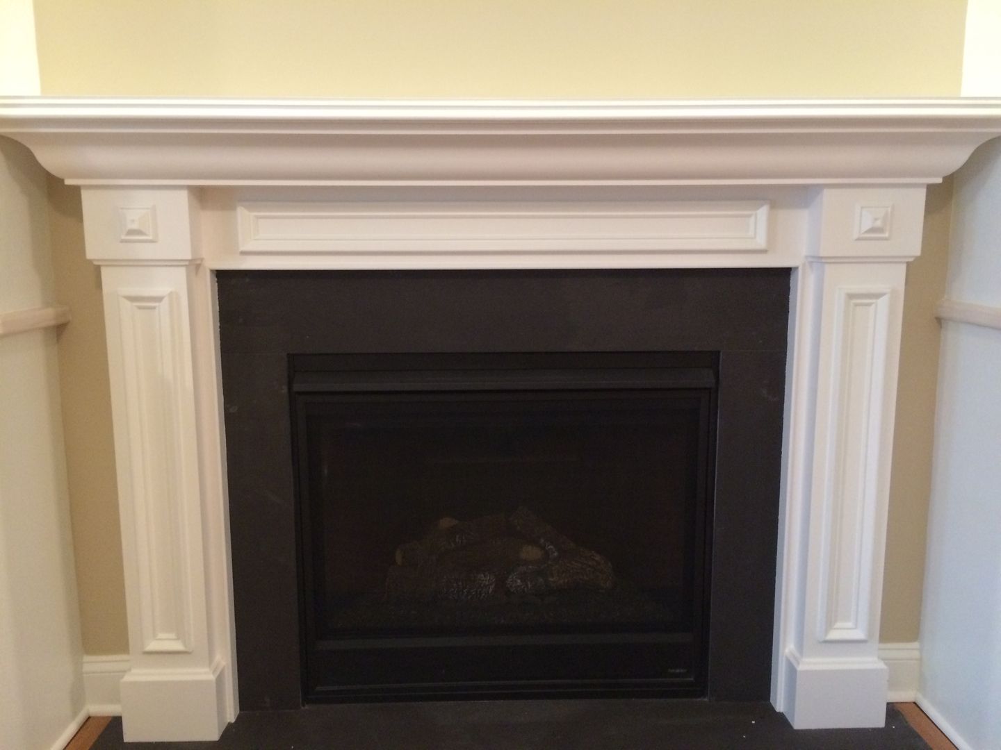 White fireplace mantel with black fireplace insert.