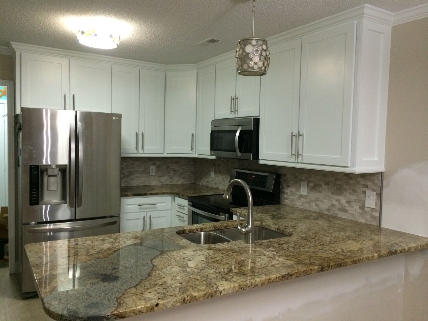 Kitchen with white cabinets, stainless steel appliances, and granite countertops.