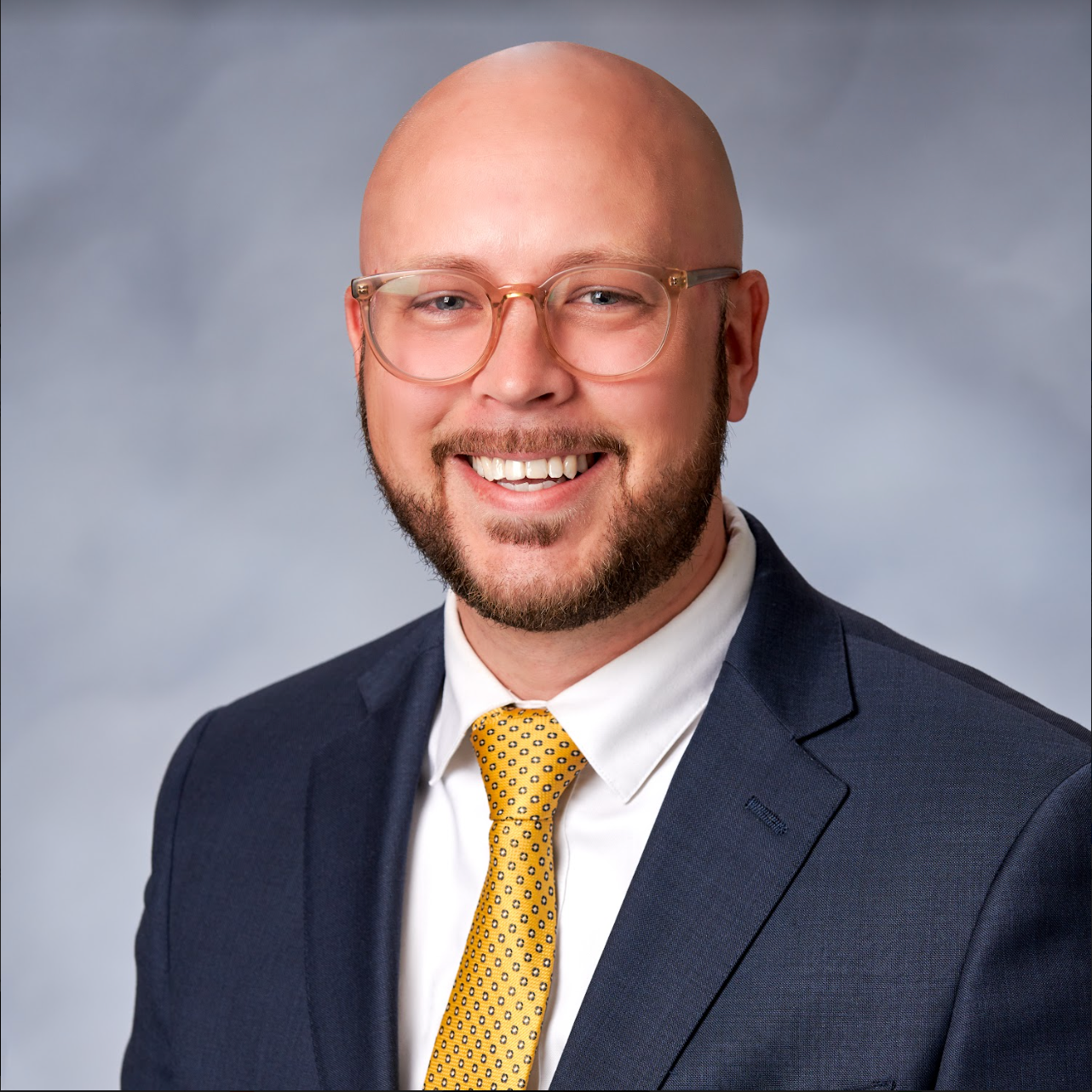 A man in a suit and tie is smiling for the camera.