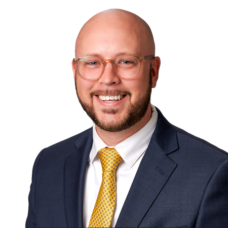 A man in a suit and tie is smiling for the camera.