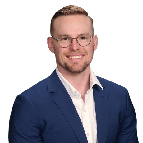 A man in a suit and tie is smiling for the camera.