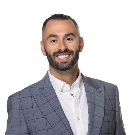 A man in a suit and tie is smiling for the camera.