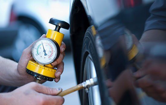 Professional Mechanic — Mechanic Measuring Tire Air Pressure in Traverse City, MI