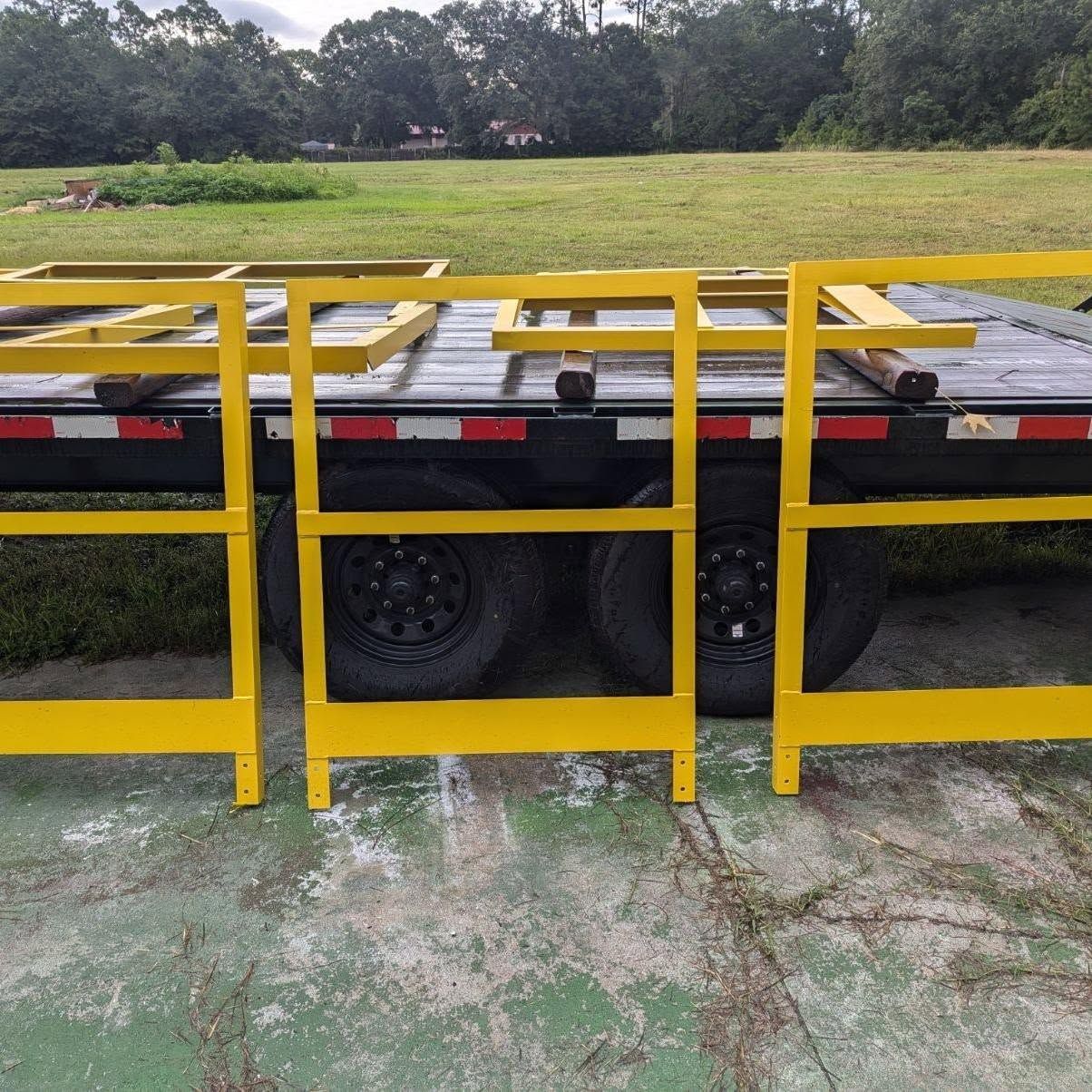 Yellow metal safety rails on a trailer, outdoors.