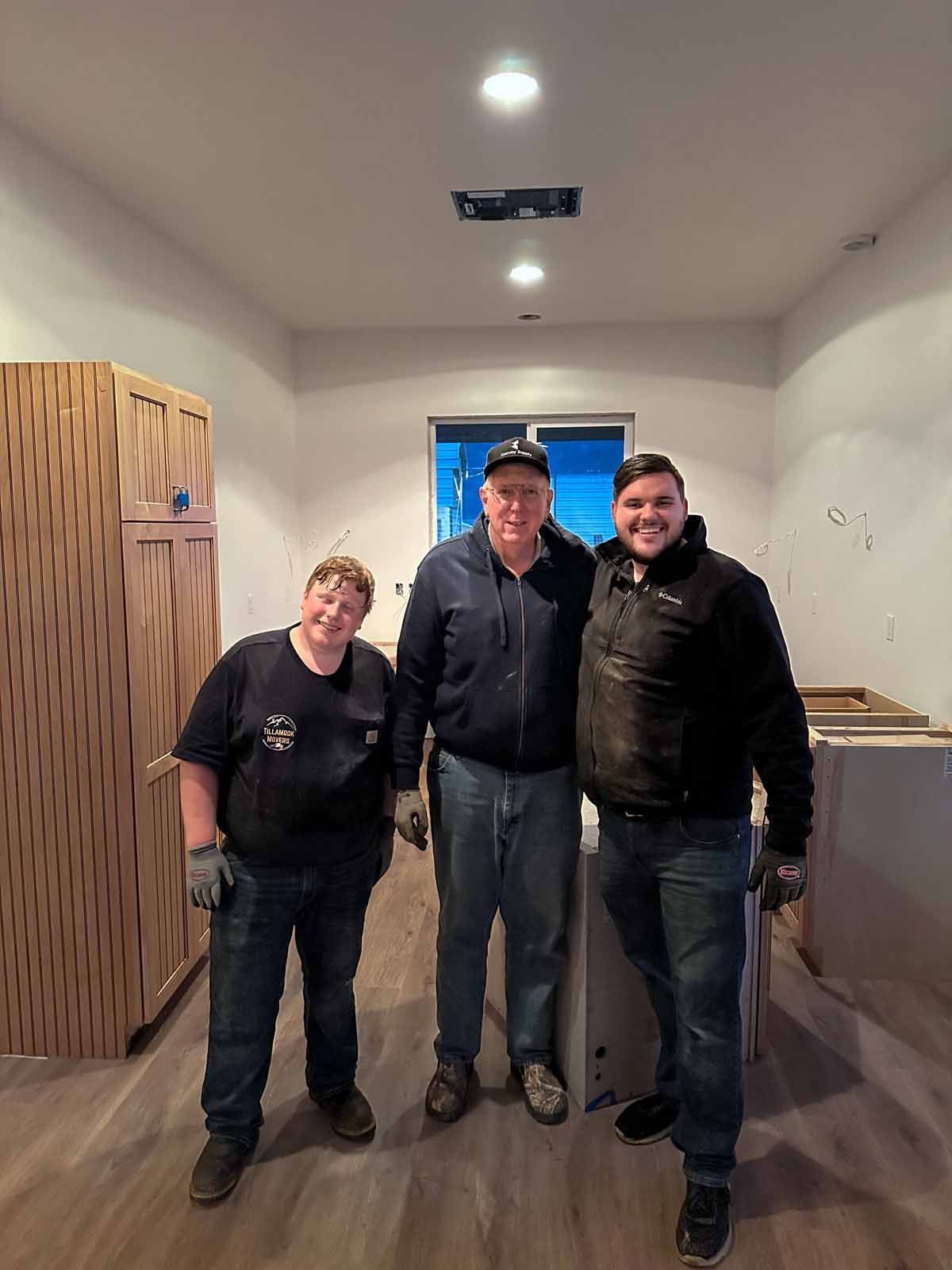 Three people are standing next to each other in a room.