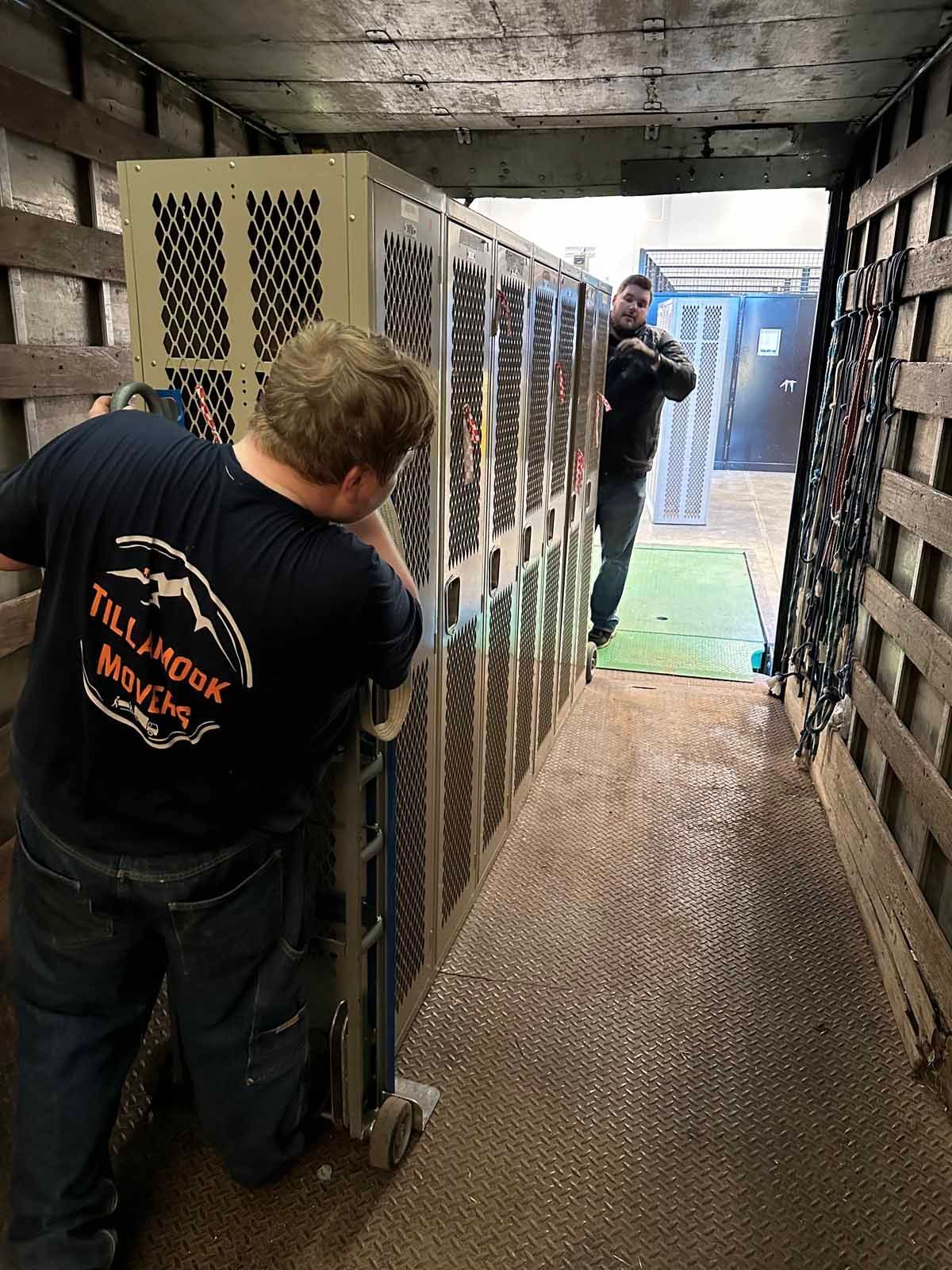 Two men are moving lockers in a truck.