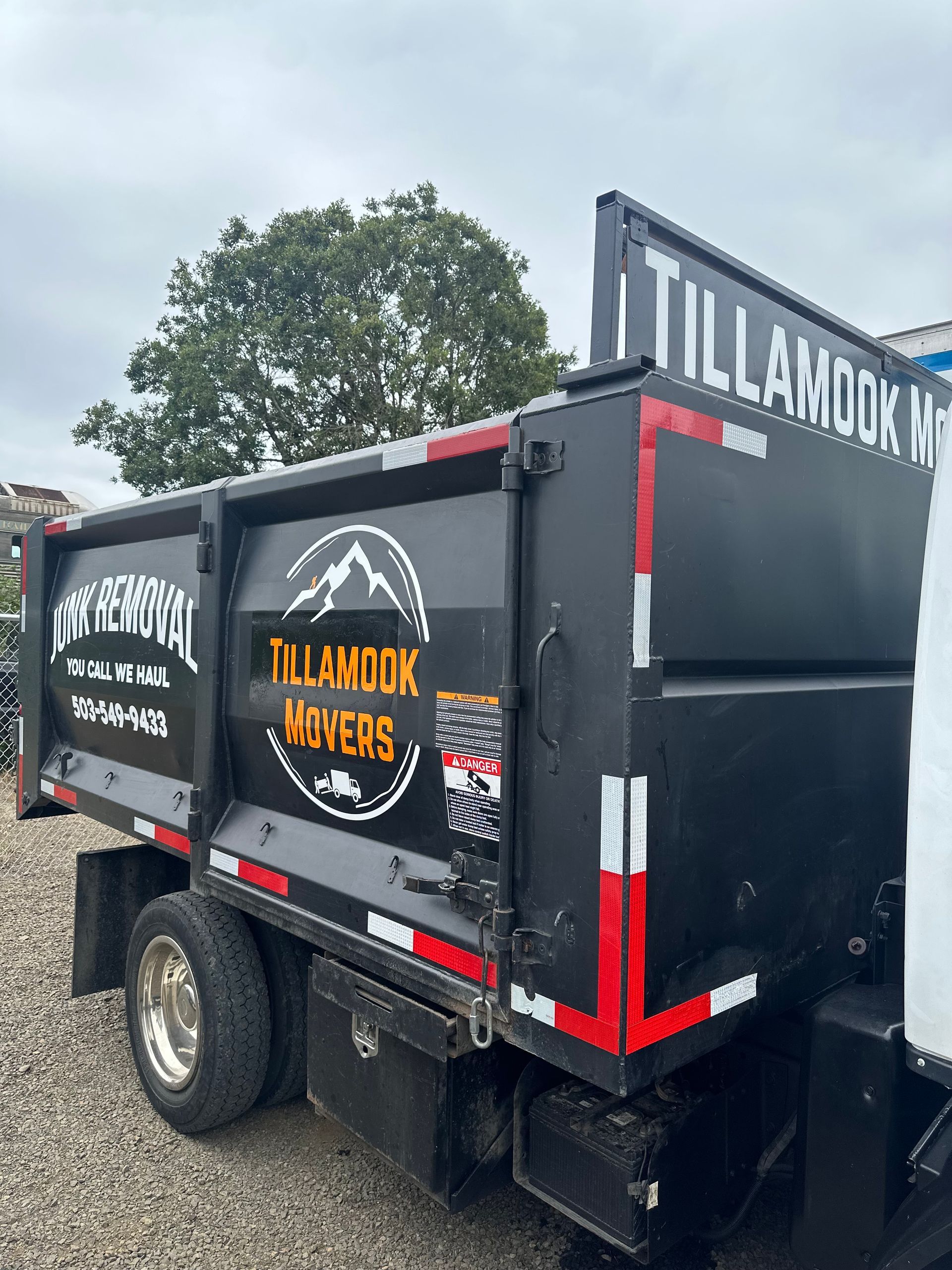 Two men are carrying boxes into a house.
