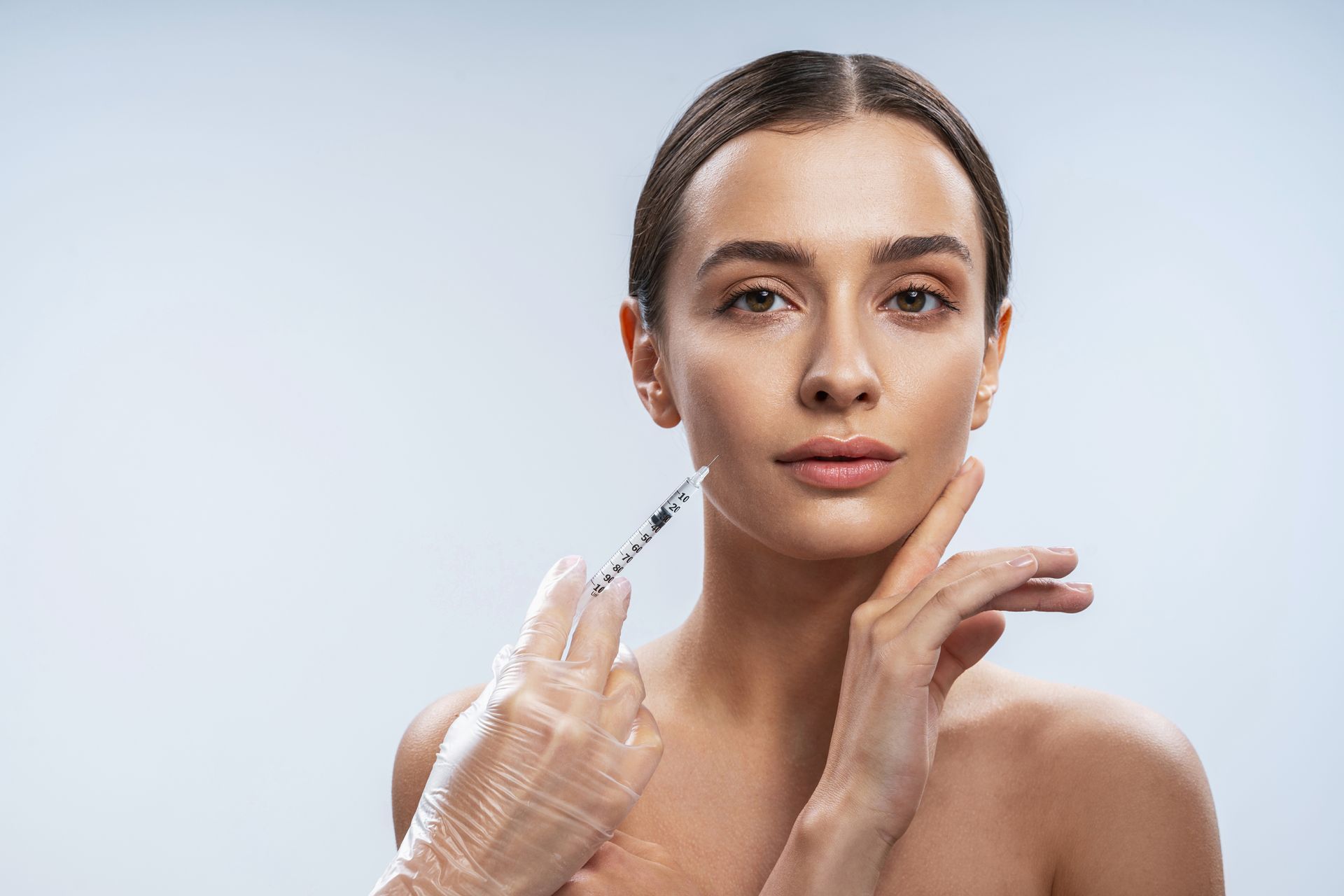 A woman is getting a botox injection in her face.