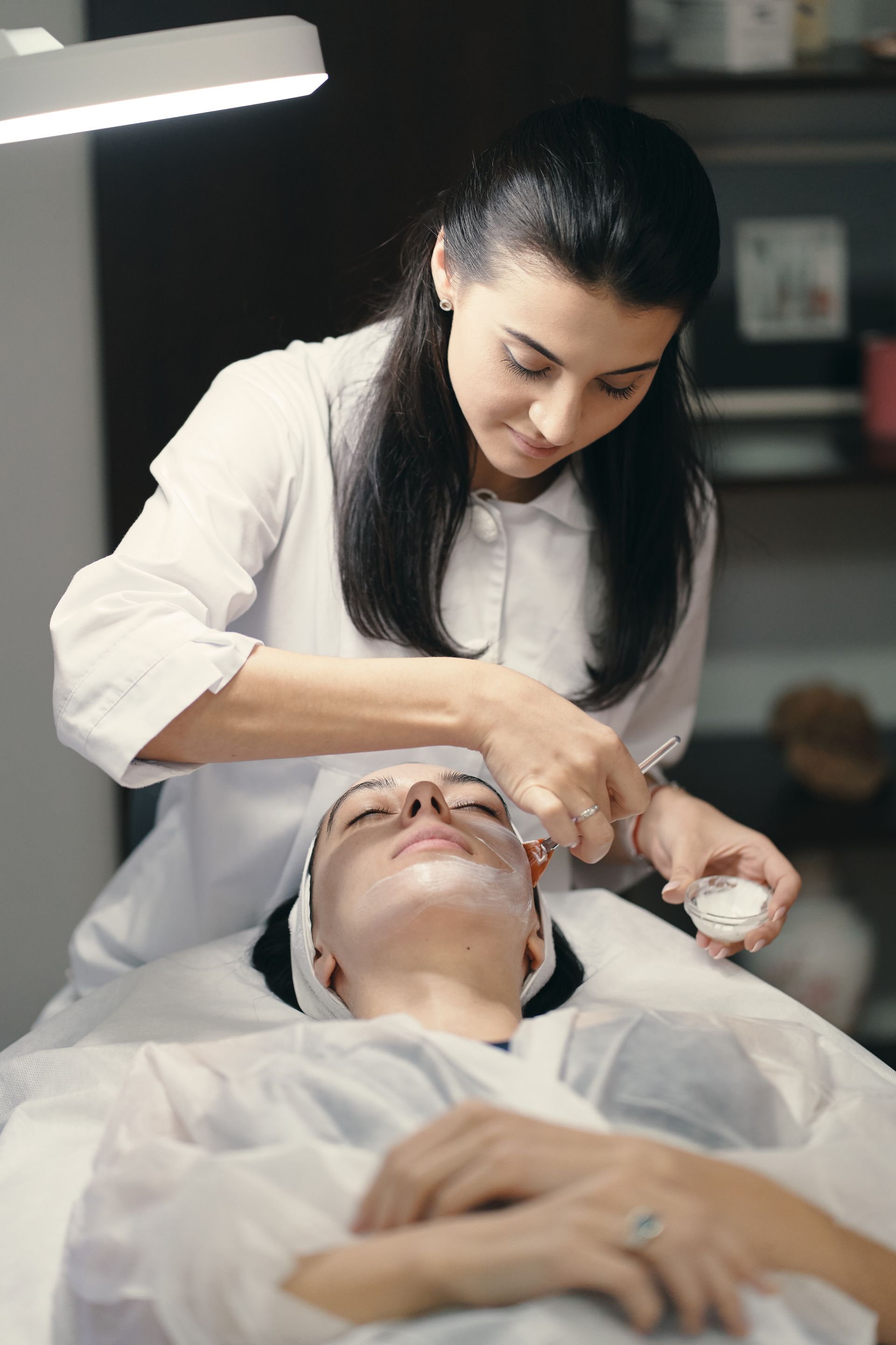 A woman is getting a facial treatment at a beauty salon.