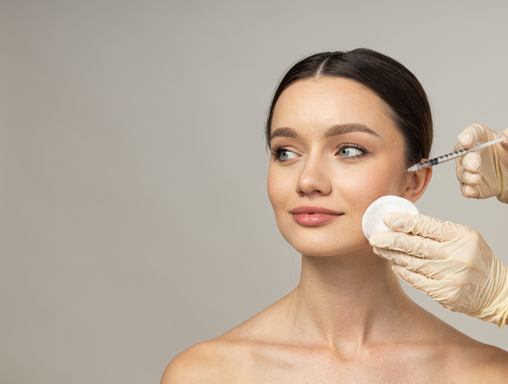 A woman is getting a botox injection in her face.