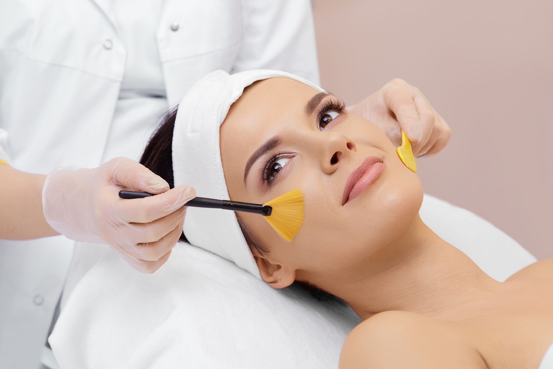A woman is getting a facial treatment at a beauty salon.