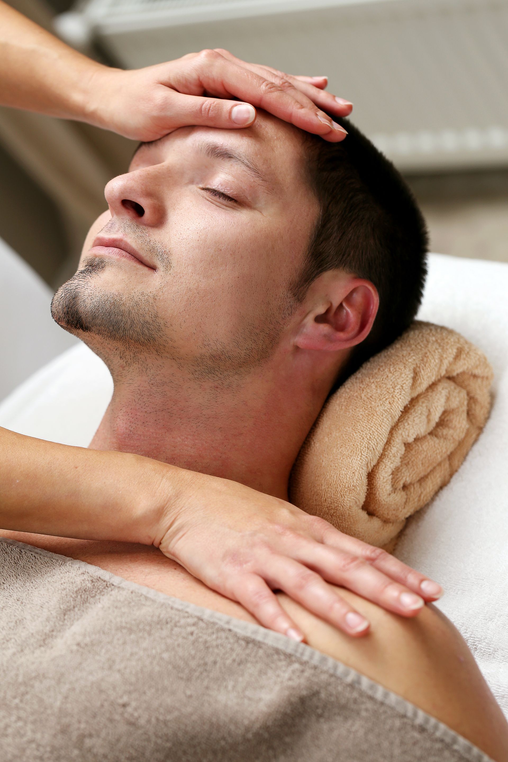 A man is getting a head massage at a spa