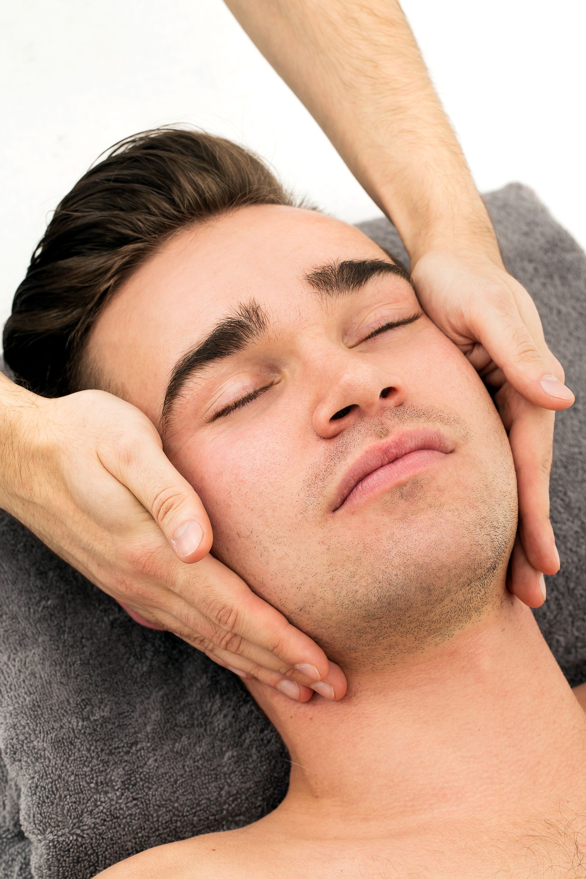 A man is getting a massage on his face in a spa.