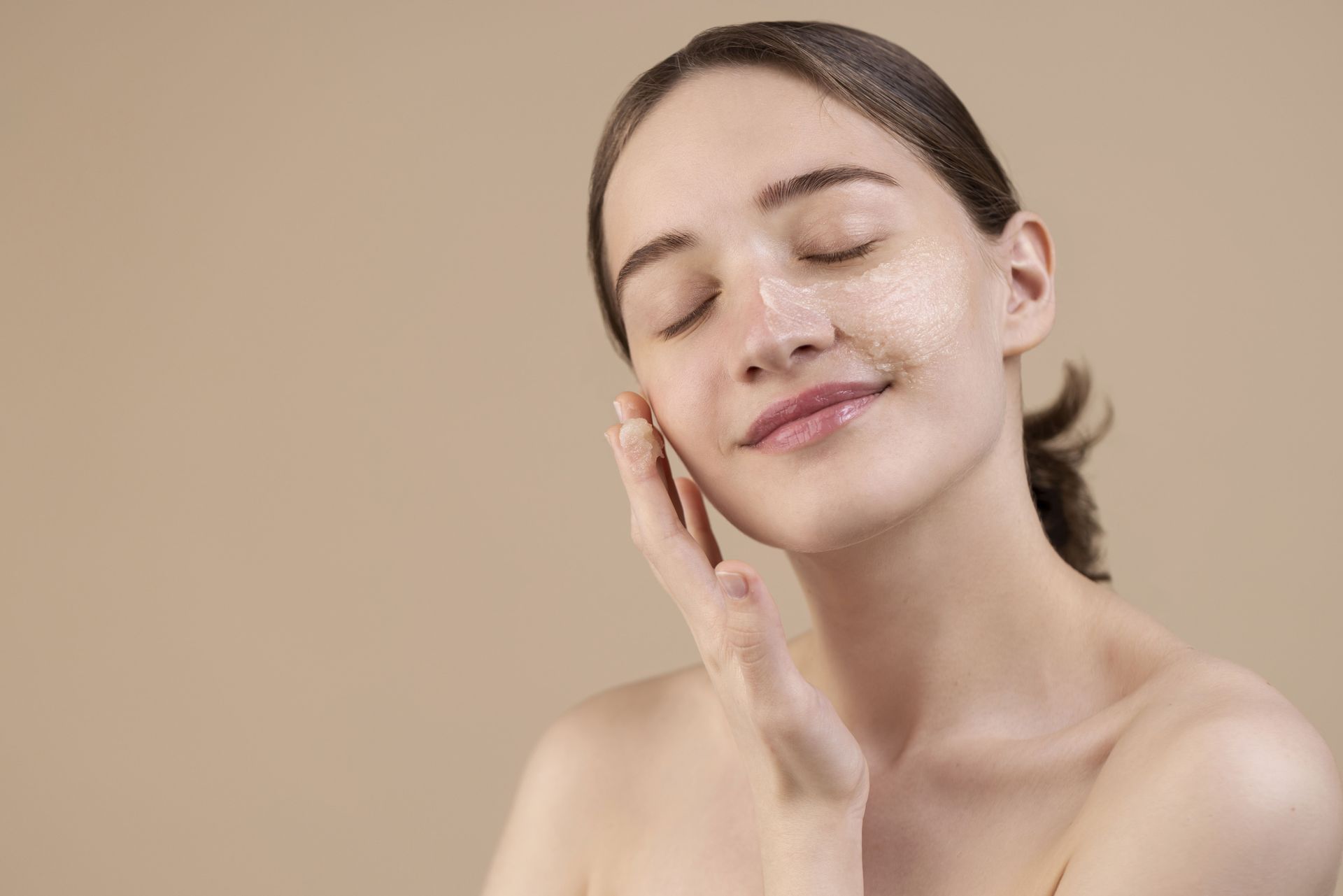 A woman with her eyes closed is touching her face with her hand.