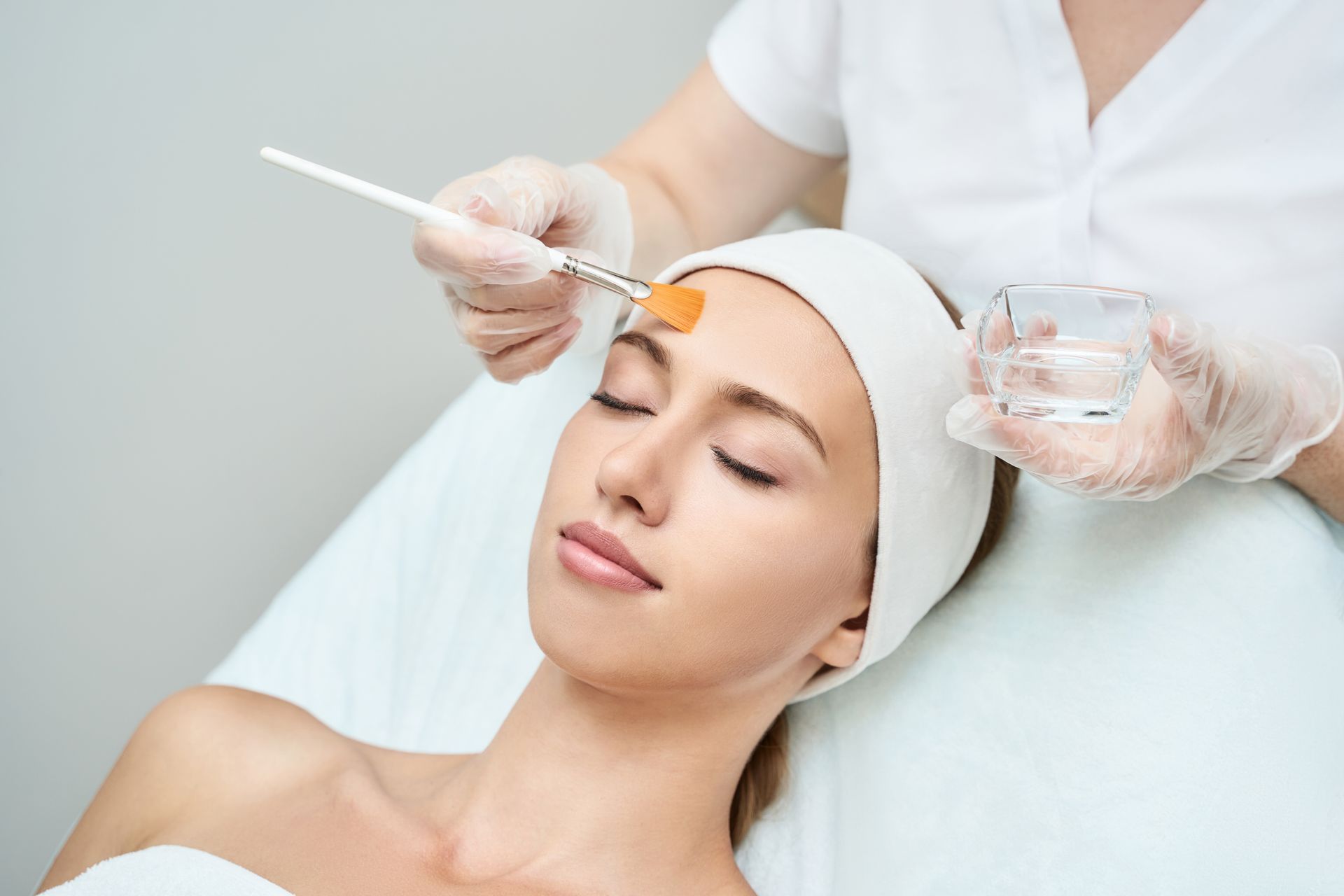 A woman is getting a facial treatment at a beauty salon.