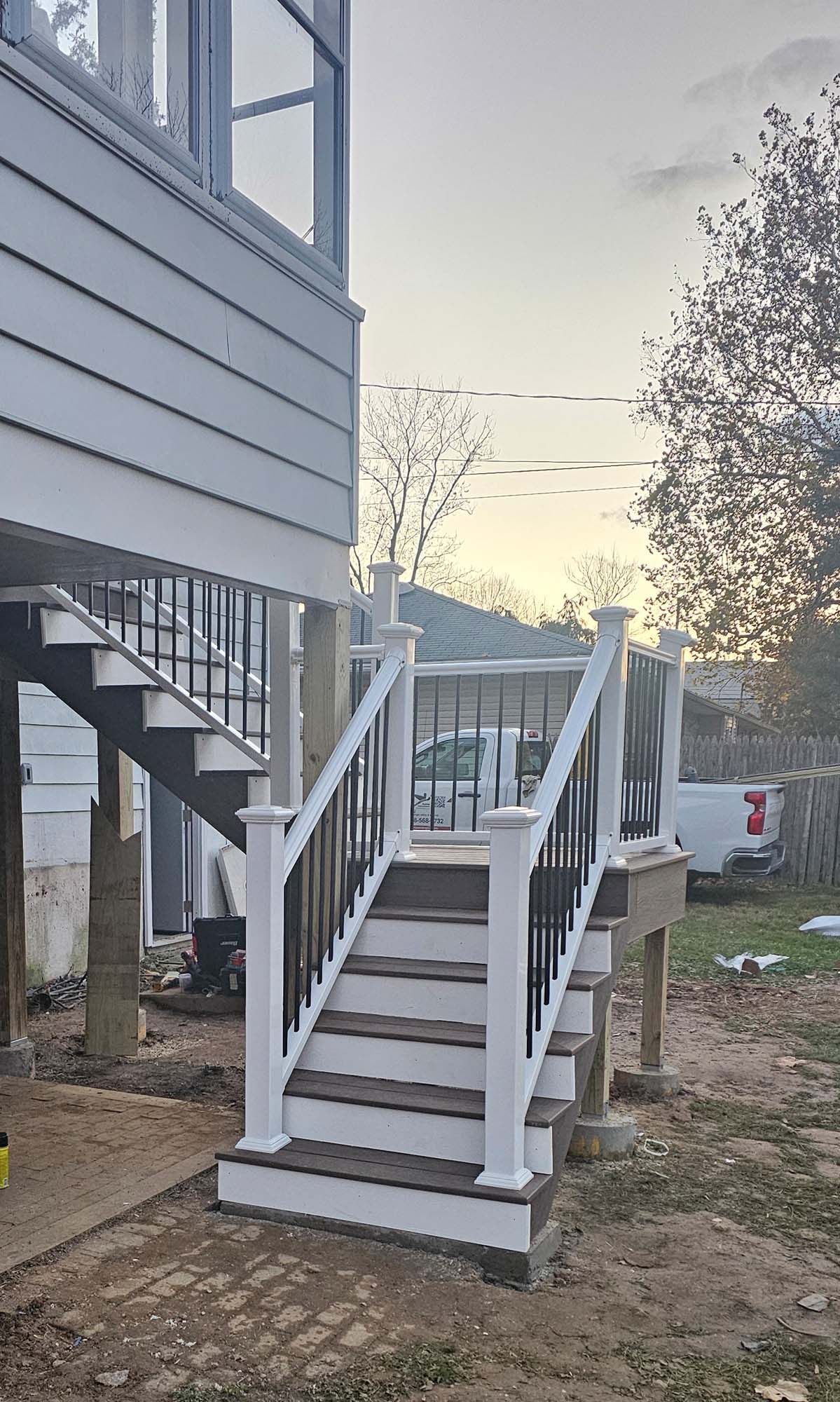 Hallway with tiled floor, antique table, and glass-paned double doors. A decorative light fixture hangs from the ceiling.