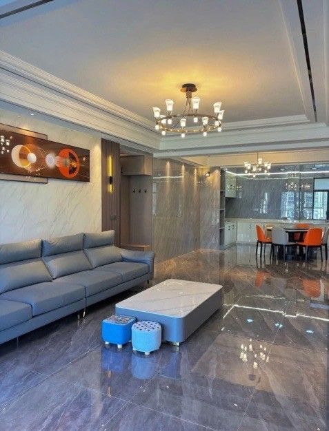 Living room with gray sofa, marble floor, and chandelier.