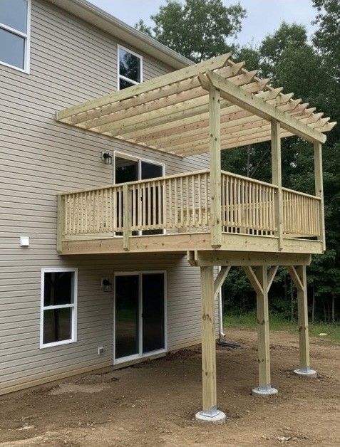 Wooden deck with a pergola attached to a two-story house.