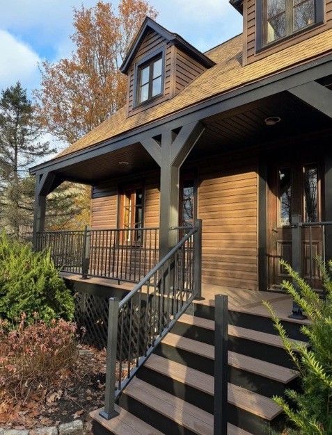 Brown house with dark trim and porch, steps leading up.