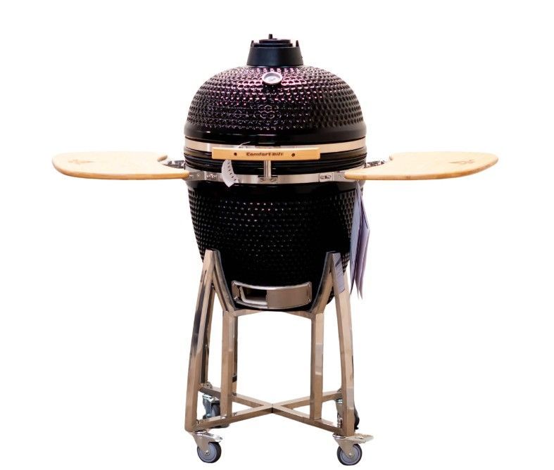 Black ceramic kamado grill on a wheeled stand with wooden side shelves