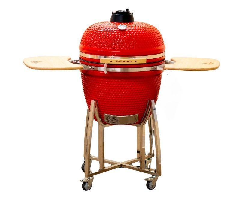 Red ceramic kamado grill on a wooden stand with side shelves and wheels