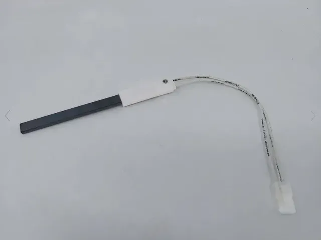 Small electronic component with a black handle, white wire, and connector on a light background