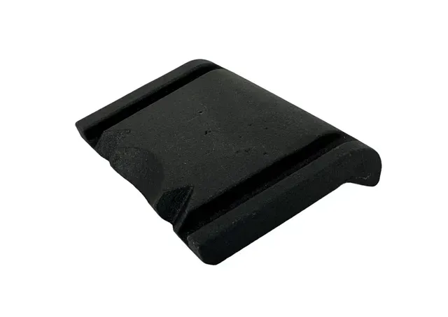 Black plastic phone stand with curved grooves on a white background