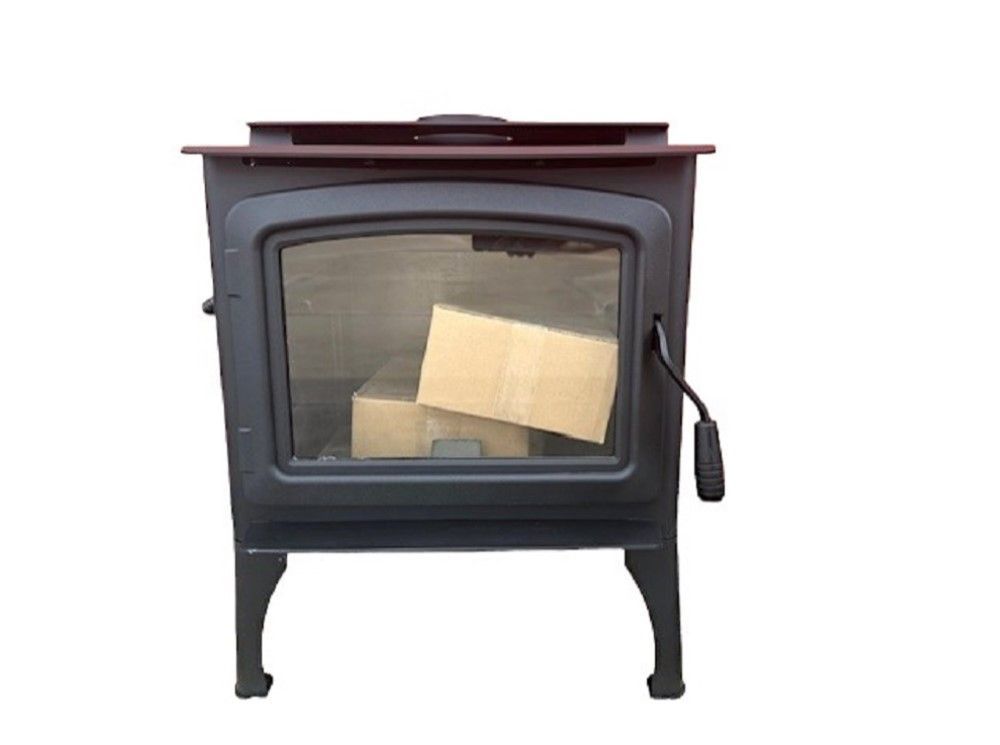 Black freestanding wood stove with glass door and visible logs inside
