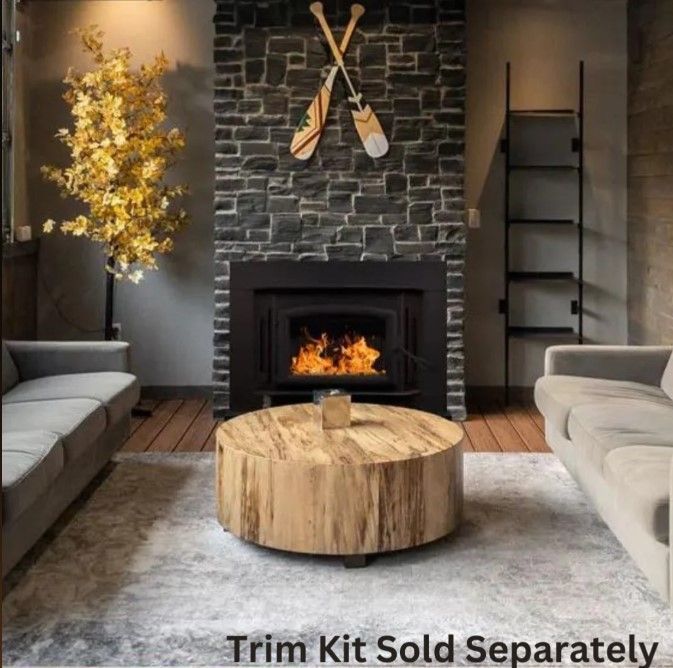 Modern living room with stone fireplace, wood coffee table, gray sofas, and crossed paddles above mantel