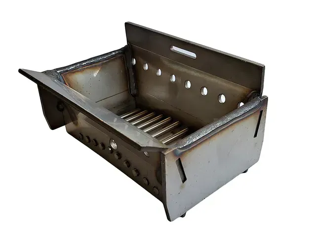 Metal foldable camping grill with open top and slotted cooking grate