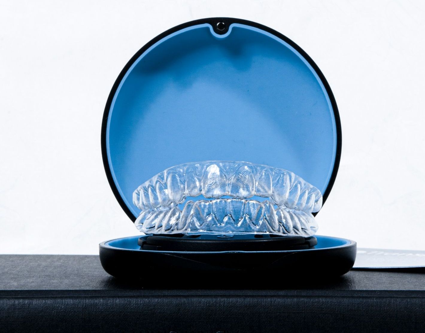 Invisalign clear aligners are sitting in their open case
