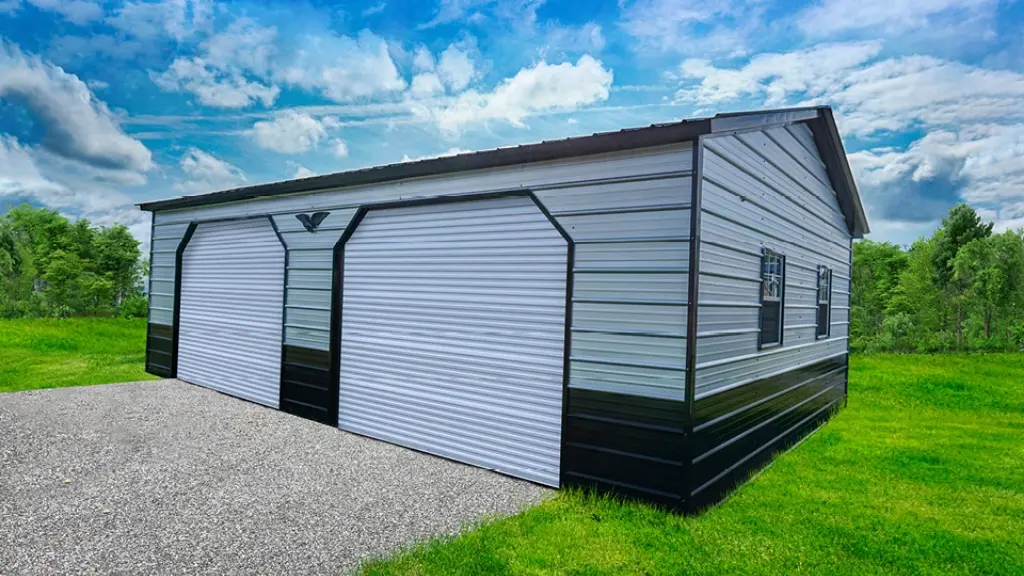 Two-car metal garage with white doors, black trim, and a gravel driveway under a blue sky.