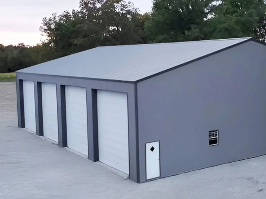 Gray metal garage with four bays and a small door and window.