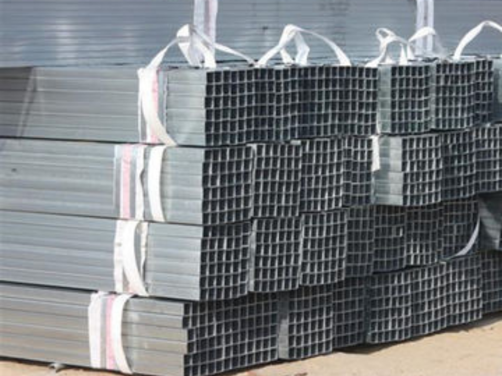 Piles of rectangular steel tubes, bound together, ready for transport.