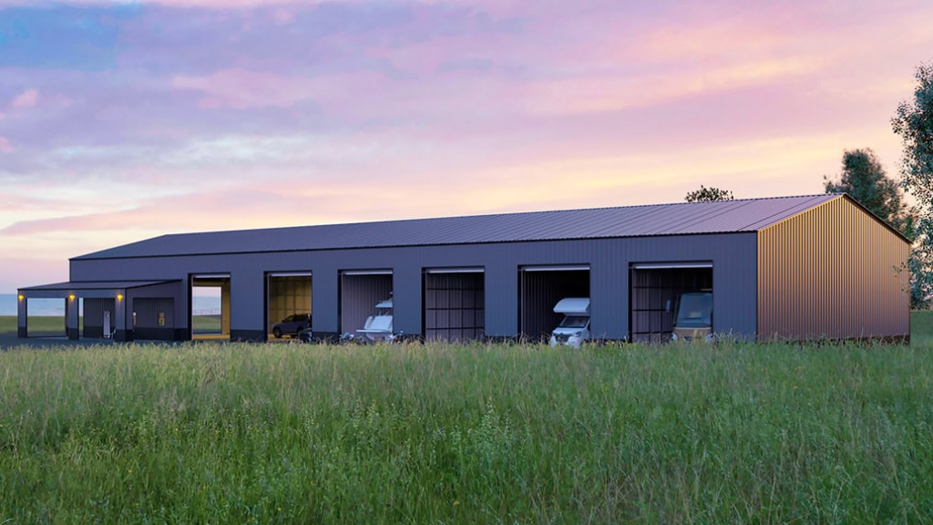 Red metal barn with open bays, storing wooden crates on pallets.