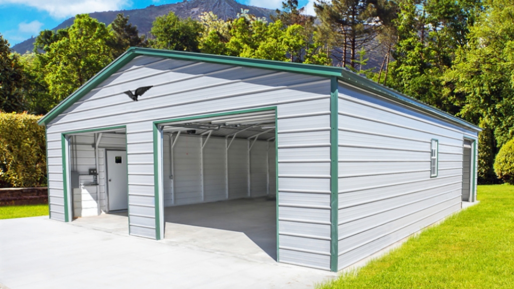 Two-car gray metal garage with blue trim and roof, concrete pad, open bays, and small entry door.