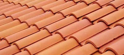 A close up of a row of red tiles on a roof.