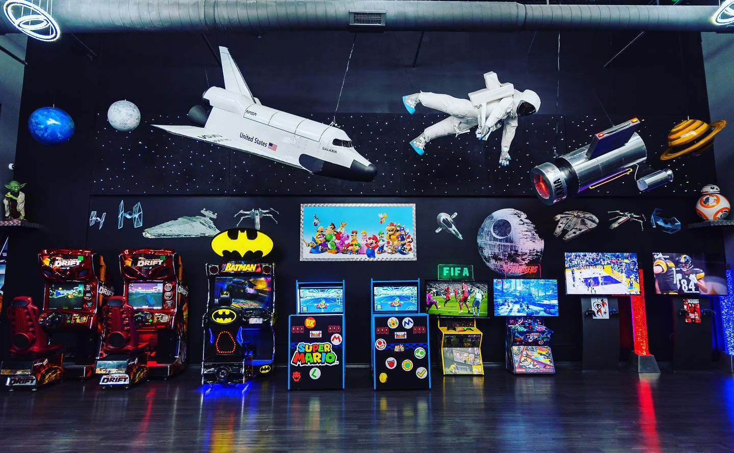 A bunch of arcade games are lined up in a room.