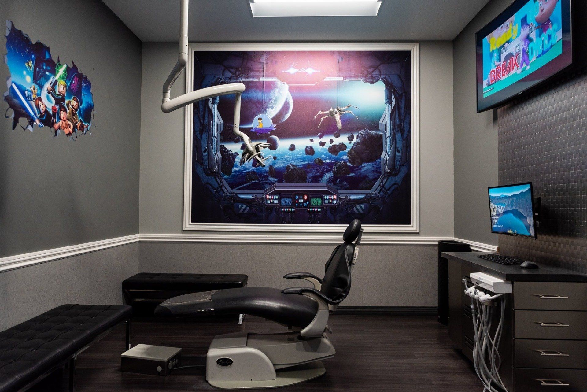 A dental office with a dental chair and a large picture on the wall.
